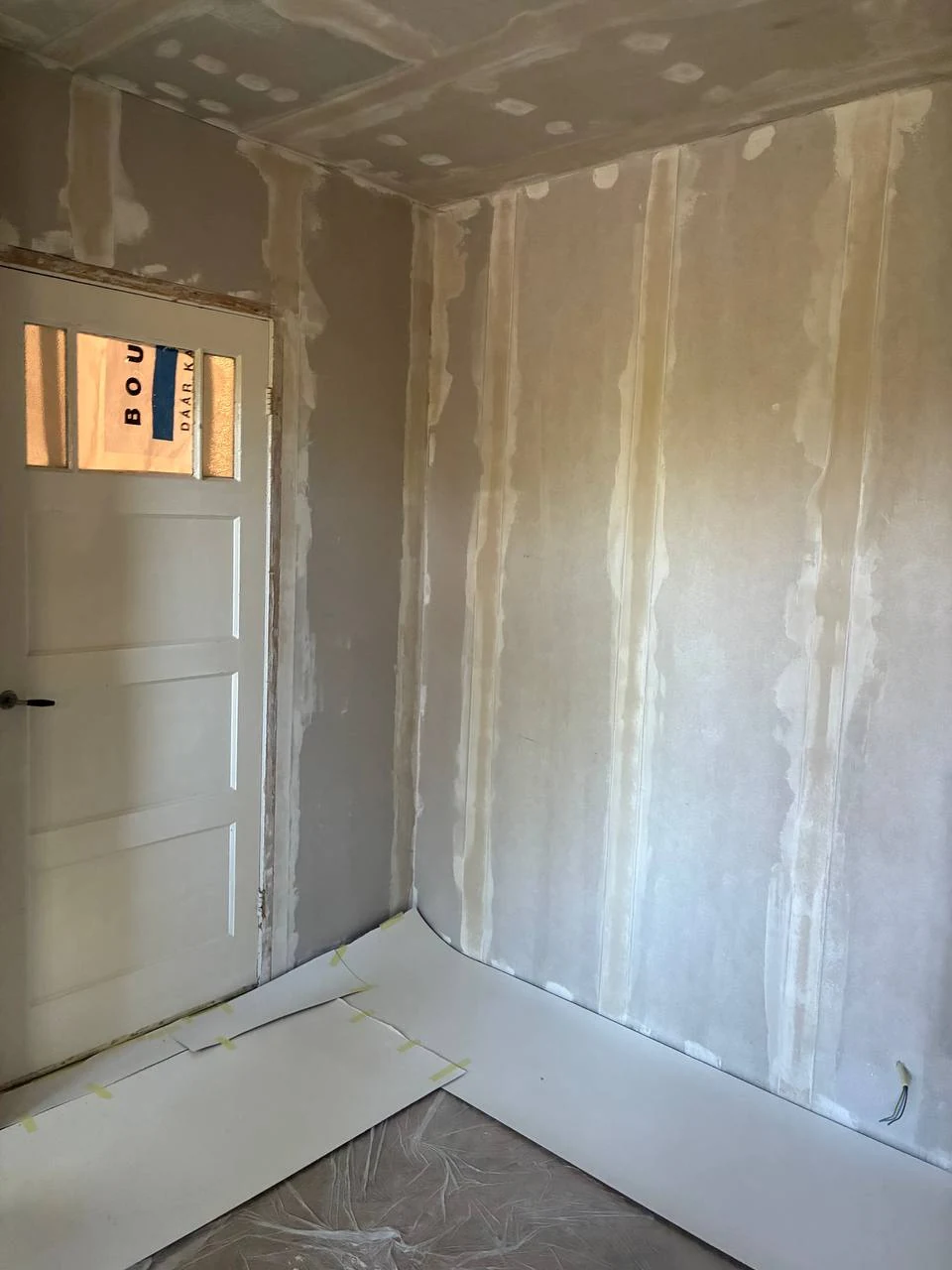 Plasterboard walls and ceiling with finished joints and screw holes in a room
