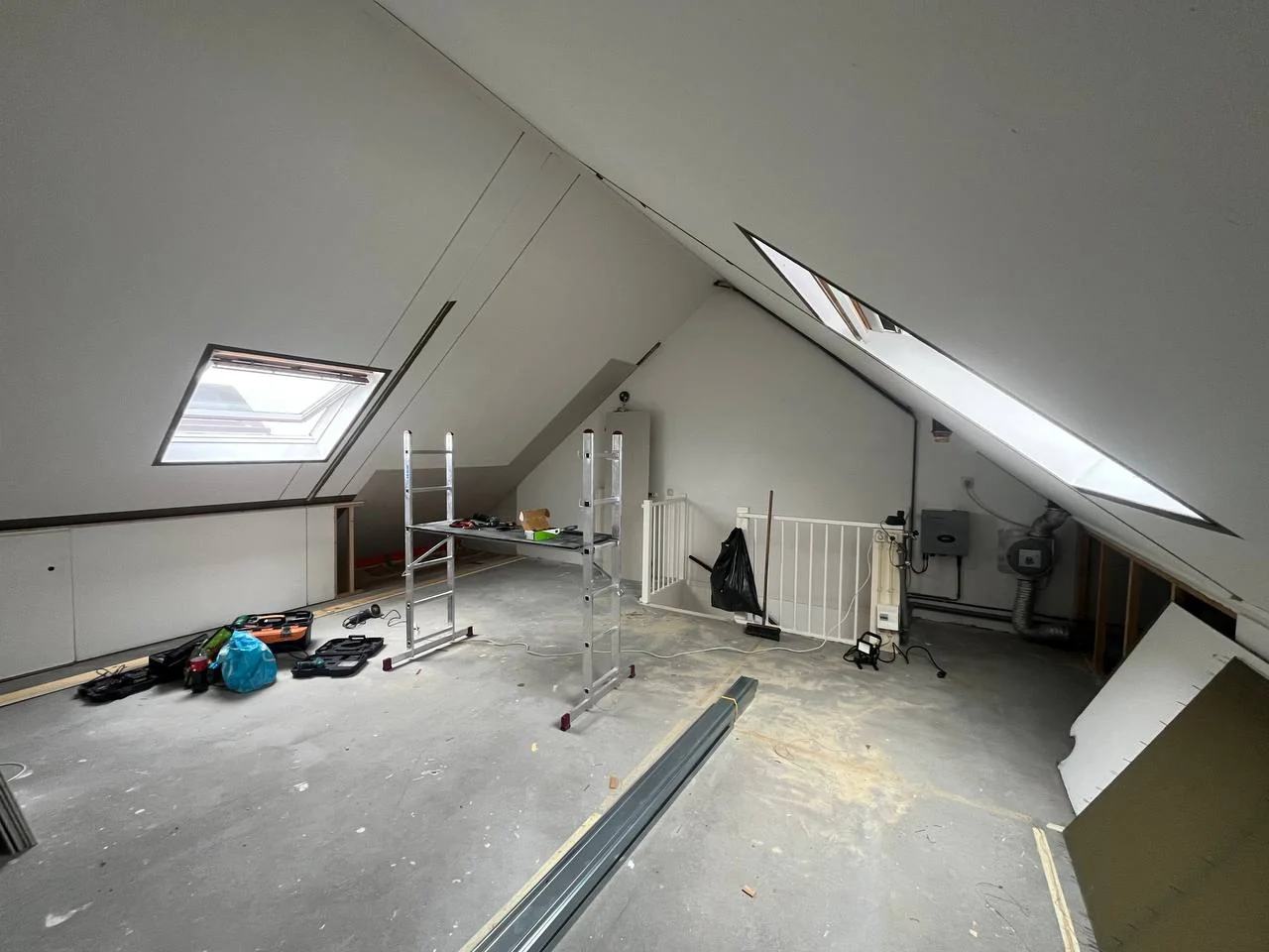Attic with plasterboard on sloped walls around roof windows