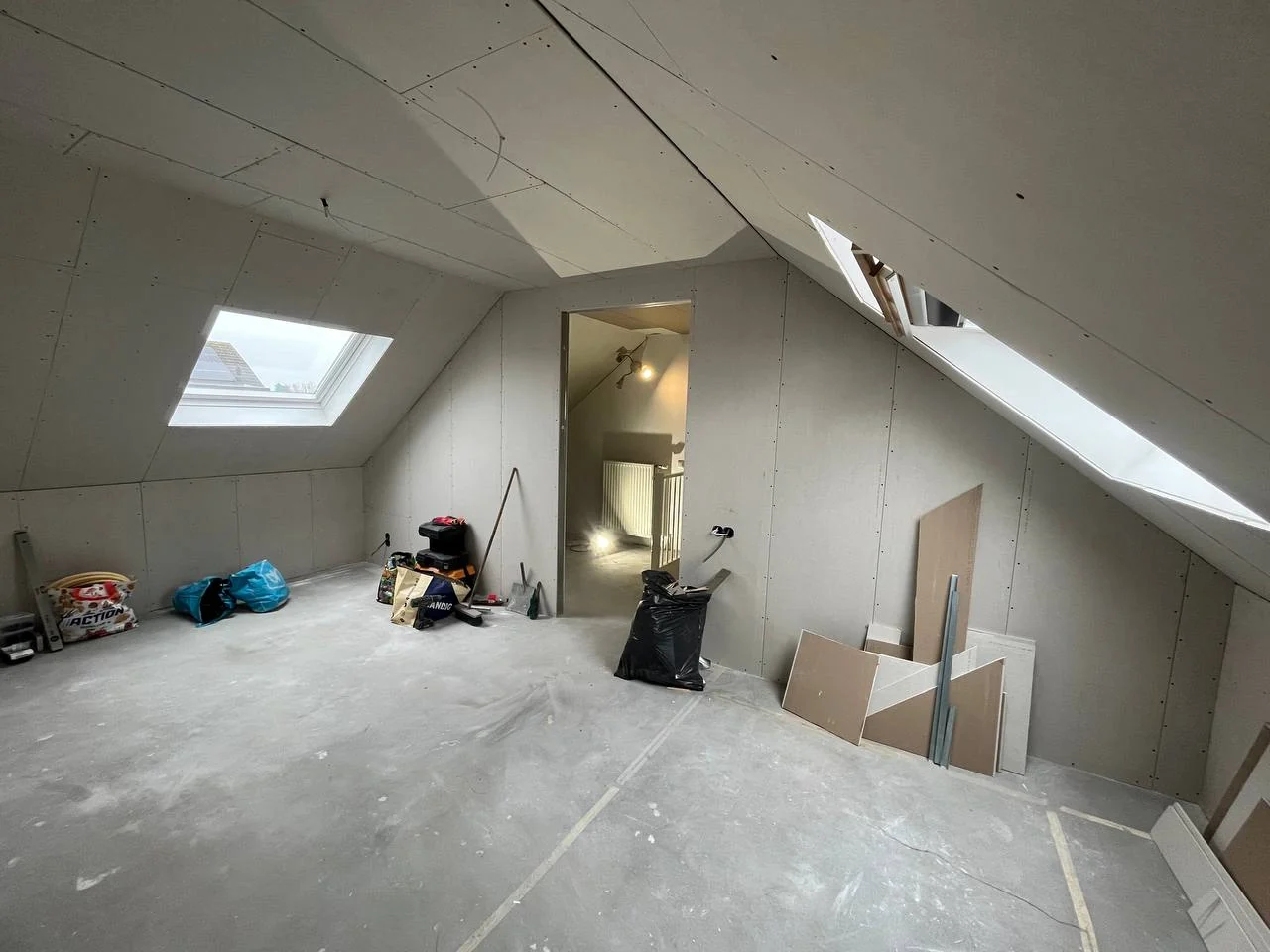 Mounted plasterboard on the walls and sloped ceiling of an attic