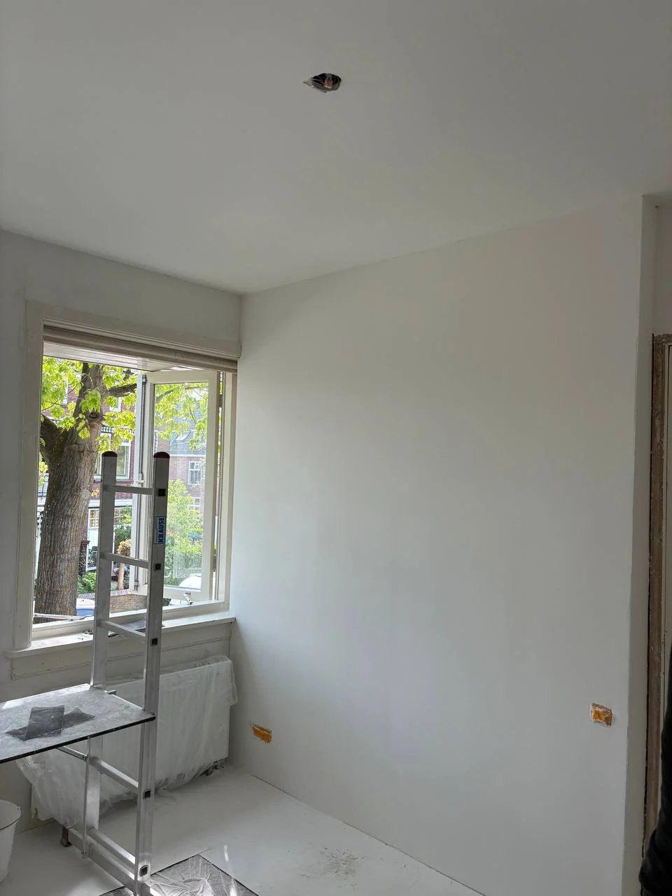 Smoothly finished and white-painted plasterboard wall and ceiling
